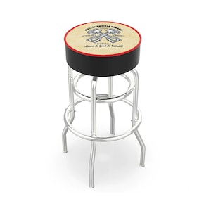 May include: A chrome-finished bar stool with a round seat featuring the text "Busted Knuckle Garage" and crossed pistons. The seat has a black top, red trim, and a beige background. The stool has a footrest and four legs.