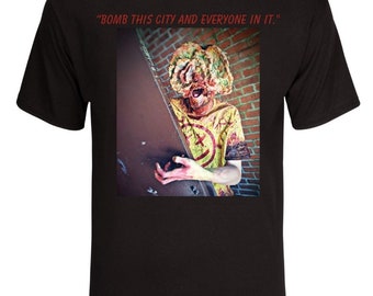 May include: Black t-shirt with a graphic print of a zombie-like figure with a pizza on its head. The text "BOMB THIS CITY AND EVERYONE IN IT." is printed above the image.