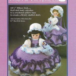 K&ouml;nnte beinhalten: Ein H&auml;kelmuster f&uuml;r eine 10 1/2 Zoll gro&szlig;e Kissenpuppe mit einem geh&auml;kelten Rock. Das Muster enth&auml;lt Anleitungen f&uuml;r ein 1,5 Zoll gro&szlig;es Bettpuppenkleid. Das Muster tr&auml;gt den Titel "Polly, Put The Kettle On".