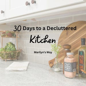 May include: A white kitchen countertop with a wooden cutting board, a glass jar of pink Himalayan salt, a bottle of sesame oil, and a small vase with white flowers. The text "30 Days to a Decluttered Kitchen" and "Marilyn's Way" is displayed on the countertop.