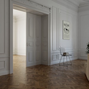 May include: A white room with a wooden herringbone floor. A white door is open to reveal another white room. A white framed poster with the text "Daily Self Care Reminders" hangs on the wall. A black and white illustration of two hands holding a heart is on the poster. A wire chair with a stack of books sits in the corner of the room.