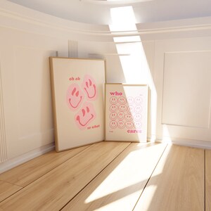 May include: Two framed prints with pink smiley faces and text. The first print says "oh ok so what" and the second print says "who cares".