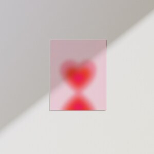 May include: A pink background with a blurry red heart shape in the center.