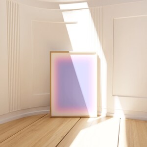 K&ouml;nnte beinhalten: Ein gerahmter abstrakter Kunstdruck mit einem Farbverlauf von Rosa, Lila und Blau. Der Druck h&auml;ngt an einer wei&szlig;en Wand mit einem Lichtstrahl, der durch ein Fenster scheint.