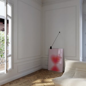 May include: A white room with a large window, a white couch, and a pink and red abstract painting hanging on the wall.