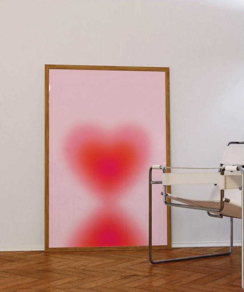 May include: A framed print with a pink background and a blurred red heart shape in the center.
