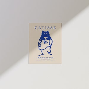 May include: A blue and white illustration of a woman with a cat sitting on her head. The text "CATISSE" is at the top of the image and "BERGGRUEN & CIE" is at the bottom. The text "PARIS, 70, RUE DE SEINE, PARIS" is below the company name.