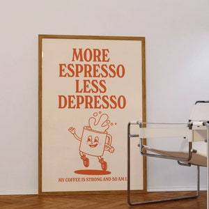 May include: A framed poster with the words "MORE ESPRESSO LESS DEPRESSO" in orange lettering. The poster features a cartoon coffee cup character and the text "MY COFFEE IS STRONG AND SO AM I."