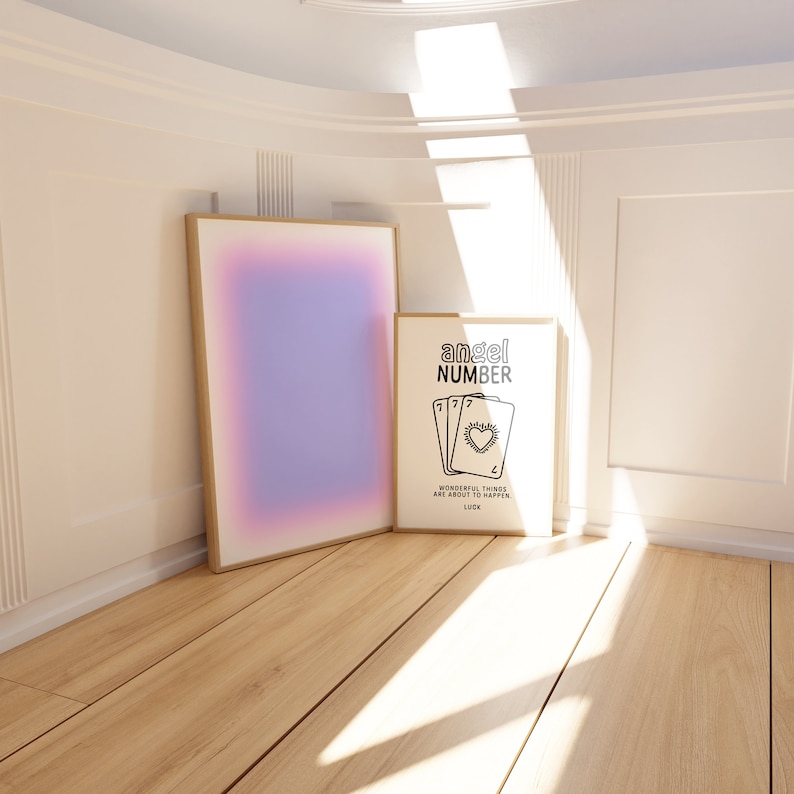 K&ouml;nnte beinhalten: Zwei gerahmte Drucke an einer wei&szlig;en Wand mit einem Holzboden. Der Druck links ist ein Farbverlauf von Rosa, Lila und Blau. Der Druck rechts ist schwarzwei&szlig; und sagt "angel number" mit einer Zeichnung von vier Spielkarten mit der Nummer 7 auf jeder Karte und einem Herz in der Mitte. Der Text unter den Karten sagt "wonderful things are about to happen. luck."