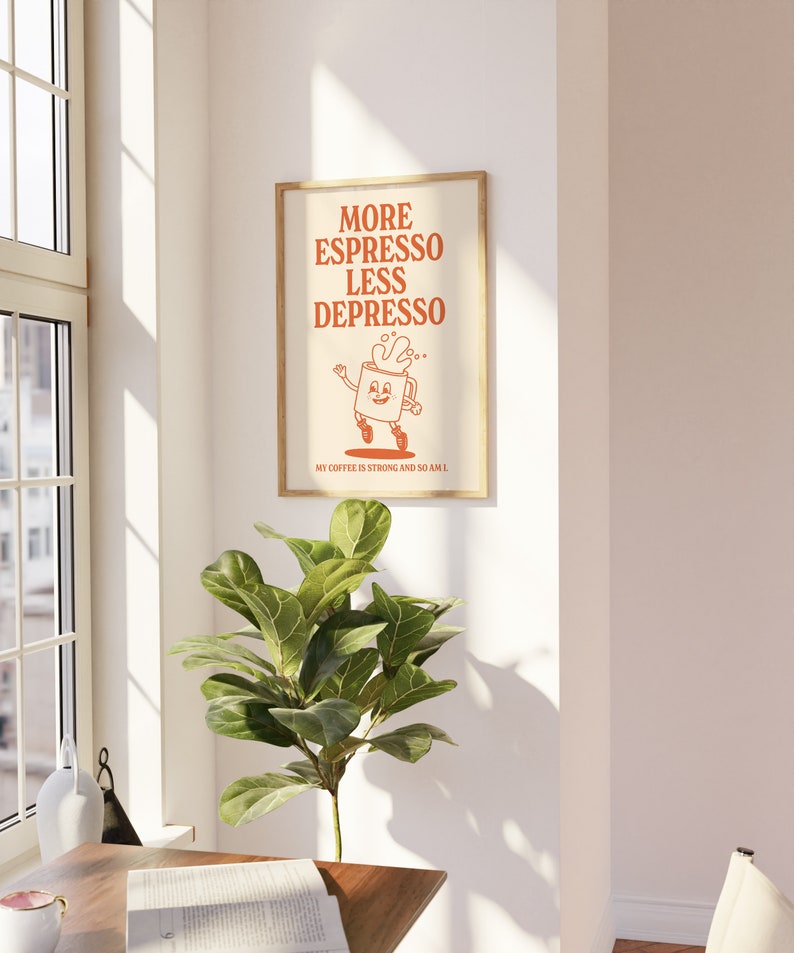 May include: A framed poster with the text "MORE ESPRESSO LESS DEPRESSO" in orange. The poster features a cartoon coffee cup character. The text "MY COFFEE IS STRONG AND SO AM I" is at the bottom. The poster is in a room with a plant.