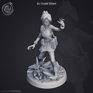 Puede incluir: Miniatura impresa en 3D de un Crystal Wizard, de pie sobre una base de formaciones cristalinas. La figura viste una túnica, pantalones y una bandolera. El texto "43. Crystal Wizard" está en la parte superior. El logo de Cast n Play está arriba a la izquierda.