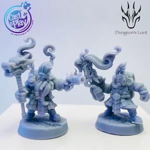 Può includere: Due miniature stampate in 3D, una con un bastone a testa di drago e l'altra con una maschera antigas e un lanciafiamme, entrambe in piedi su basi circolari. Le miniature sono dipinte di un colore grigio chiaro. L'immagine include il testo "Dungeon's Loot" nell'angolo in alto a destra.