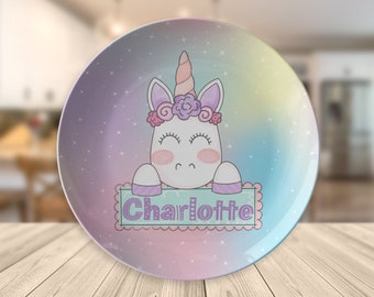 May include: A pastel rainbow colored plate with a white unicorn with a purple flower crown and the name "Charlotte" written on a green banner.