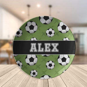 May include: A green and black personalized plate with a soccer ball pattern and the name "ALEX" in white letters.