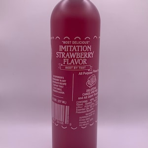 May include: A red plastic bottle of imitation strawberry flavoring. The bottle is labeled "Most Delicious" Imitation Strawberry Flavor, Best by Test, All Purpose Flavoring. The bottle contains 9 fl oz (237 ml) and is made by Superior Products Co. in Charlotte, NC.