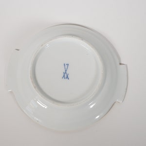 May include: White porcelain saucer with a blue and white mark on the bottom. The mark is a crossed sword with the letter 'V' above it.