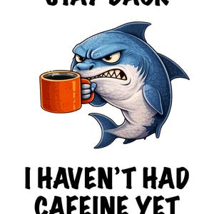 May include: A cartoon illustration of an angry blue shark holding an orange coffee mug. The image includes the text "STAY BACK" above the shark and "I HAVEN'T HAD CAFFEINE YET" below.