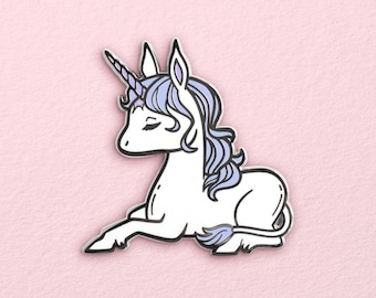 May include: A white unicorn with a purple mane and a silver horn, lying down with its head turned to the side. The unicorn is a cartoon-style enamel pin.