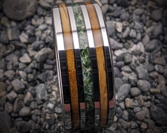 May include: A silver and wood ring with green accents. The ring has a polished finish and is made of durable materials.