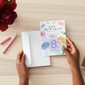 May include: A light blue and purple invitation card with a watercolor illustration of a mermaid, a narwhal, and a jellyfish. The text on the card reads "Let's "Shell"abrate!" March 13th at 4 PM. Our Little Mermaid Clara 8. 123 Anywhere St. Any City, ST 12315. RSVP: [phone number].