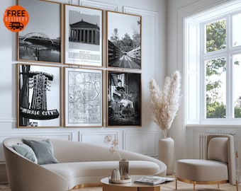 Puede incluir: Un interior de sala de estar con un sofá blanco, una mesa de café, una silla y un jarrón alto con hierba de pampa seca. Las paredes están decoradas con fotos enmarcadas en blanco y negro de Nashville, Tennessee. Las fotos incluyen una vista del horizonte de la ciudad, un mapa de la ciudad, una foto de un puente y una foto de un edificio.