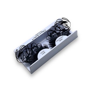 May include: A pair of black false eyelashes in a white box. The box says "101# Black" and "100% Human Hair".