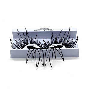 Puede incluir: Dos pares de pestañas postizas negras en una caja blanca con el texto "Sephora Lashes Professional" impreso en la caja.