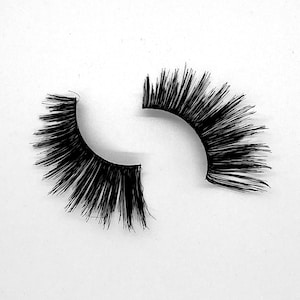 May include: A pair of black false eyelashes, one is a full lash and the other is a half lash.