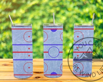 Könnte beinhalten: Drei Edelstahlbecher mit einem Eishockeyfeld-Design. Die Becher sind blau, rot und weiß mit einem Used-Look. Die Becher stehen auf einer Holzoberfläche.