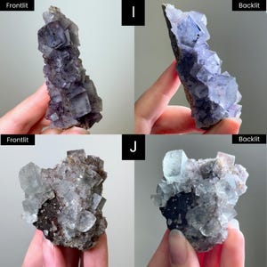 May include: Two clusters of raw fluorite crystals labeled I and J. Cluster I features deep purple cubic formations. Cluster J displays translucent, pale, and clear cubic crystals attached to a dark, textured mineral matrix base.