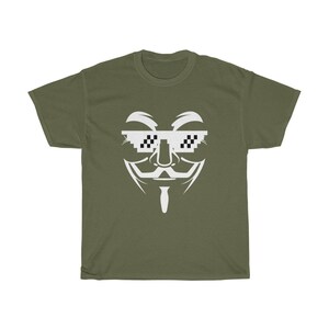 Puede incluir: Una camiseta verde con un gr&aacute;fico blanco de la m&aacute;scara de Anonymous con gafas de sol pixeladas. Las gafas tienen un patr&oacute;n de cuadros blanco y negro.