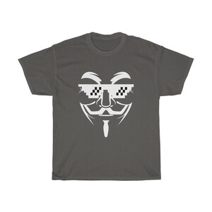 Puede incluir: Una camiseta gris oscuro con un gr&aacute;fico blanco de la m&aacute;scara de Anonymous con gafas de sol pixeladas. Las gafas tienen un patr&oacute;n de cuadros blanco y negro.