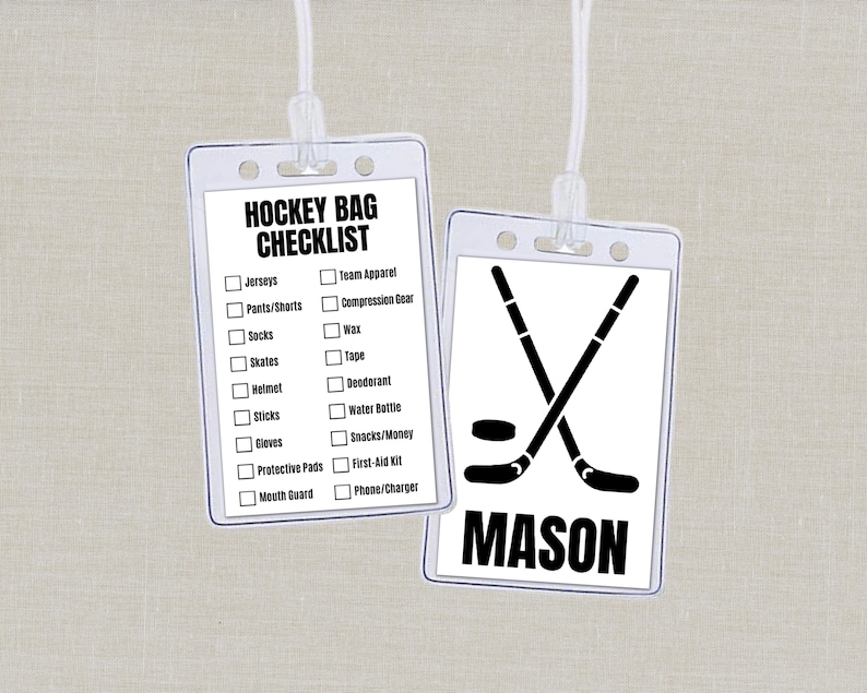 May include: Two clear plastic hockey bag tags with white cords. One tag has a checklist of hockey gear. The other tag has crossed hockey sticks, a puck, and the name "MASON" in black.