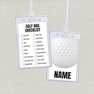 May include: Two rectangular clear plastic luggage tags with white inserts. One tag features a black printed GOLF BAG CHECKLIST with checkboxes for items like golf shirt, clubs, and rangefinder. The other tag displays a white golf ball and the word NAME.