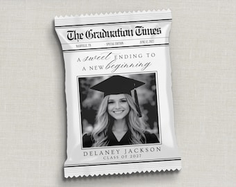 May include: A white rectangular snack bag with a serrated top and bottom edge. The front features a newspaper-style header reading The Graduation Times, the text A sweet ending to a new beginning, a black and white photo of a graduate, and the name Delaney Jackson Class of 2027.