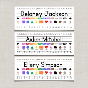 Op de afbeelding: Drie naamlabels met de namen Delaney Jackson, Aiden Mitchell en Ellery Simpson in het zwart gedrukt. Elk label heeft een handschriftgids, kleurgecodeerde vormen en een getallenlijn van 0 tot 20. De achtergrond is lichtbeige.