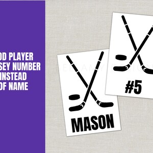 May include: Two white cards with black hockey stick and puck graphics. One card has the name "MASON" and the other has the number "5". A purple background on the left has the text "ADD PLAYER JERSEY NUMBER INSTEAD OF NAME".