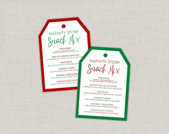 May include: Two rectangular paper gift tags with rounded top corners and a hole punch. One tag has a red border, the other a green border. Both feature the text NATIVITY STORY Snack Mix and a list of ingredients with religious descriptions.