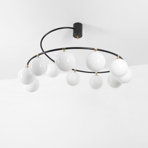 May include: A modern ceiling light fixture with a black metal frame and ten white glass globes.