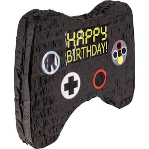 Könnte beinhalten: Schwarz-weiße Videospiel-Controller-förmige Piñata mit dem Text "Happy Birthday!" in gelben Buchstaben.