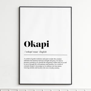 May include: A framed print with the word "Okapi" in bold black font. Below, the definition and a description of the Okapi are printed in a smaller, black font. The frame is black, and the background is white.