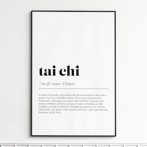 May include: A black framed print featuring the words "tai chi" in a bold, black font. Underneath, a definition of tai chi is printed in a smaller font. The definition describes tai chi as a dance of harmony and balance.