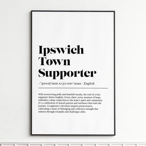 May include: Black framed print with the words "Ipswich Town Supporter" in bold black font. Below the title is the phonetic pronunciation and the word "noun". The print also includes a paragraph describing the meaning of a supporter.