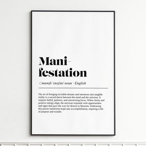 以下が含まれることがあります： 「Manifestation」という単語が太字で書かれた、黒と白のフレームに入ったプリント。その下に、定義と説明が小さなフォントで印刷されています。デザインはミニマリストです。