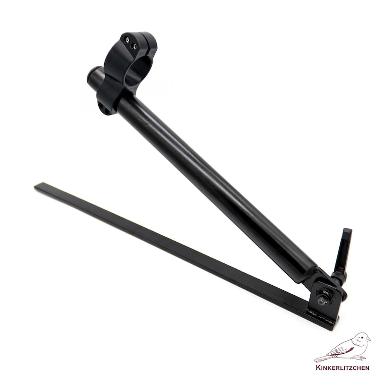 May include: A black metal camera accessory with a circular clamp, a long angled arm, and a flat base. The accessory is designed to hold a camera or other equipment. The item is on a white background.