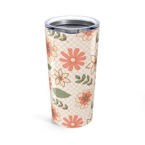 May include: A stainless steel tumbler with a checkered pattern and a floral design in shades of peach, cream, and green.