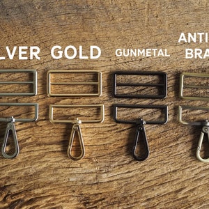 May include: Four metal slider buckles with matching swivel hooks in silver, gold, gunmetal, and antique brass.
