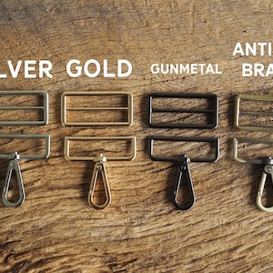 May include: Four metal slider buckles with matching swivel hooks in silver, gold, gunmetal, and antique brass.