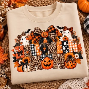 Könnte beinhalten: Ein beigefarbenes Sweatshirt mit Rundhalsausschnitt und einem Grafikdruck mit dem Text HALLOWEEN MOM. Das Design zeigt Kürbisse, Geister, Sonnenblumen, Fledermäuse und Schleifen in orangefarbenen, schwarzen und Leopardenmustern, umgeben von Herbstblättern.