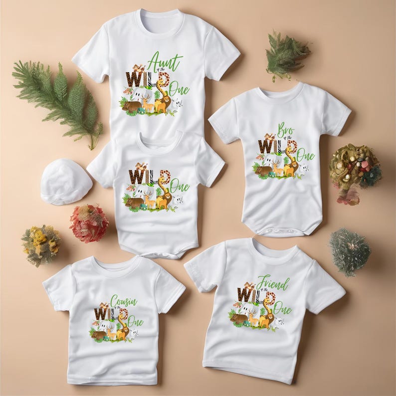 May include: Set of four white t-shirts with a jungle animal theme. The shirts say "Aunt of the Wild One", "Bro of the Wild One", "Cousin of the Wild One", and "Friend of the Wild One".